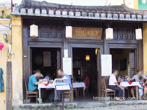 午後早めの時間帯にホイアン旧市街のトゥボン川沿いにあるカフェで寛ぐ観光客